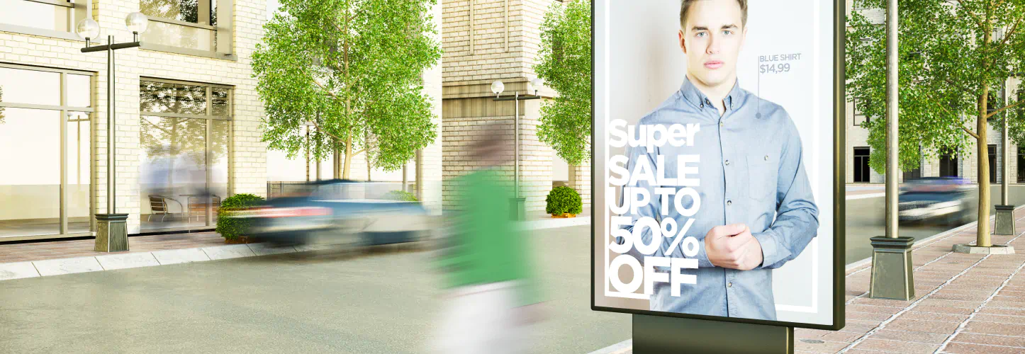People walk past a sign for a clothing sale.