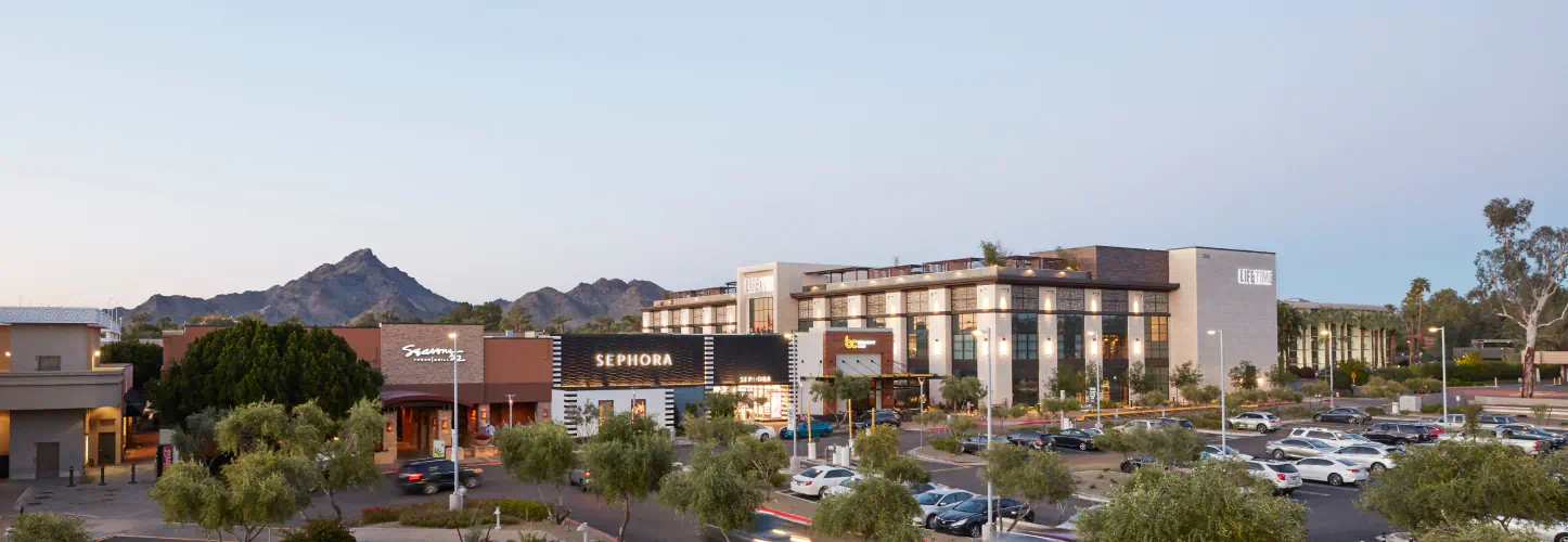 A wide angle shot of the many storefronts at Biltmore Fashion Park. Cars are parked in the lots.