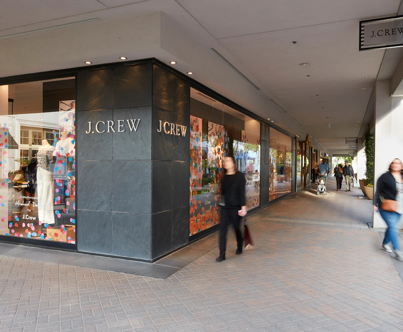 People walk in front of the entrance to J. Crew.