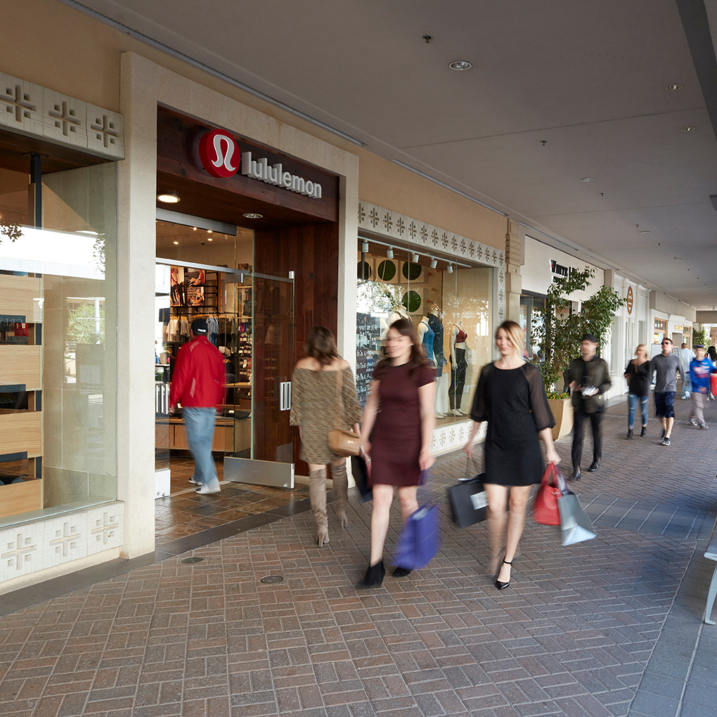 Two women walking past lululemon store front