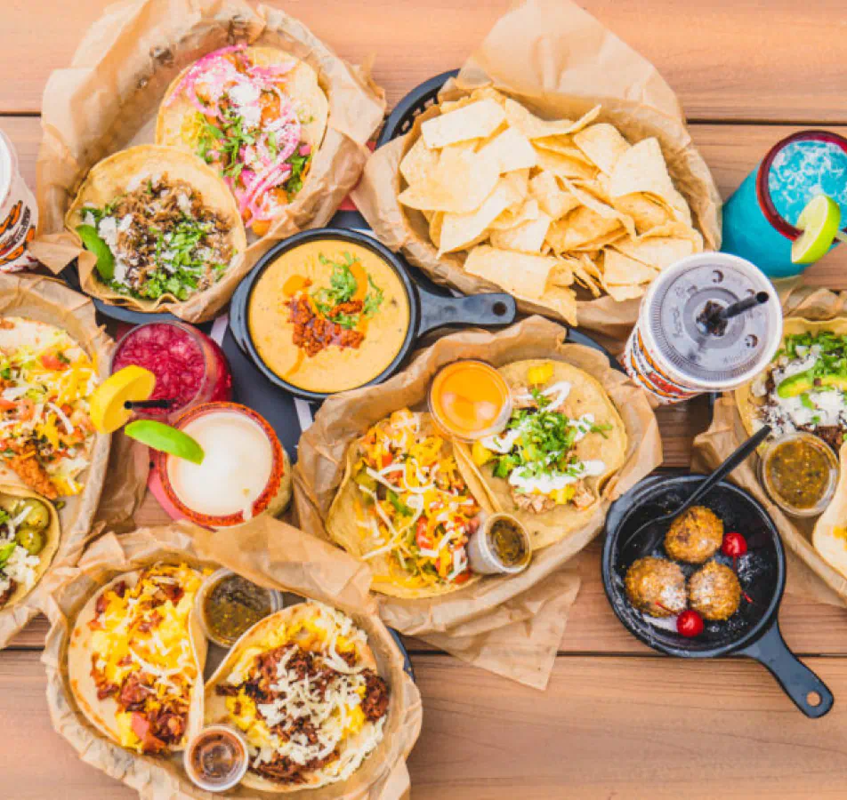 a spread of many kinds of mexican food laid out on a table, shot from above.