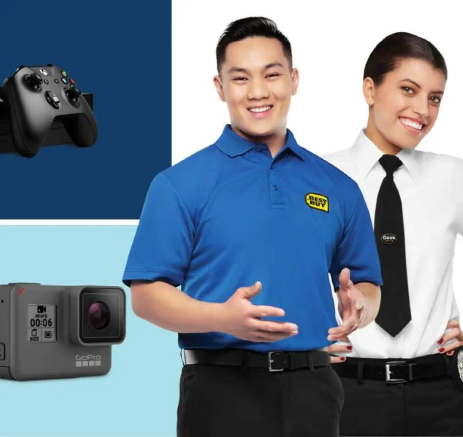 Happy Best Buy employees posing infront of an image of a camera and game controller