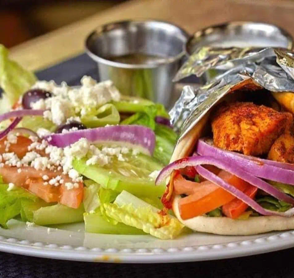 Pita wrap and salad with dressing on the side.