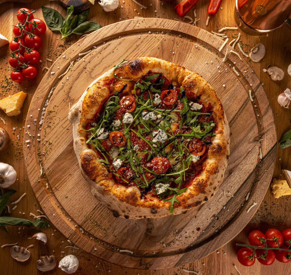 Pizza sitting on circular wood serving board shot from above