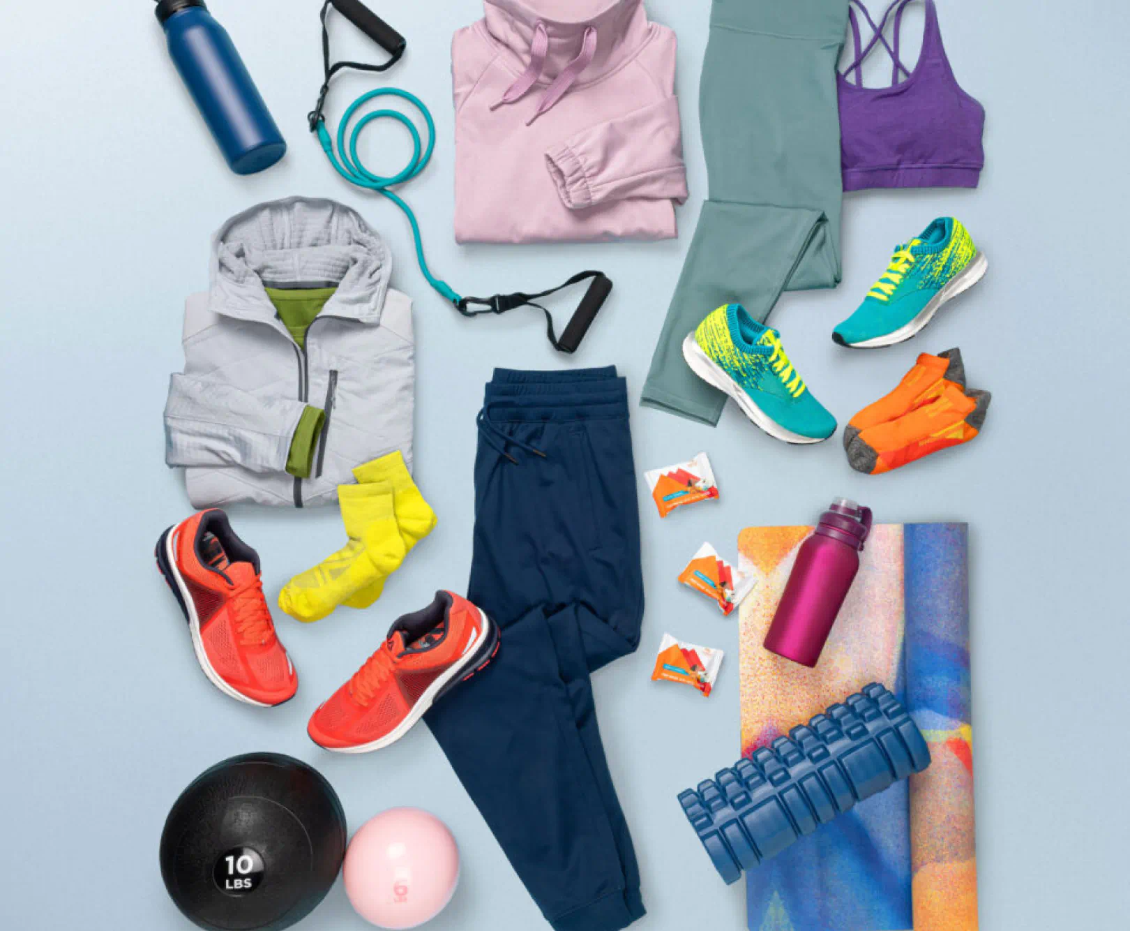 Assorted athletic clothing, shoes, fitness accessories, and equipment arranged on a light blue background.