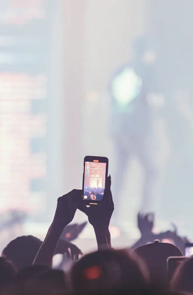 Concert with a concert goer recording on their phone.