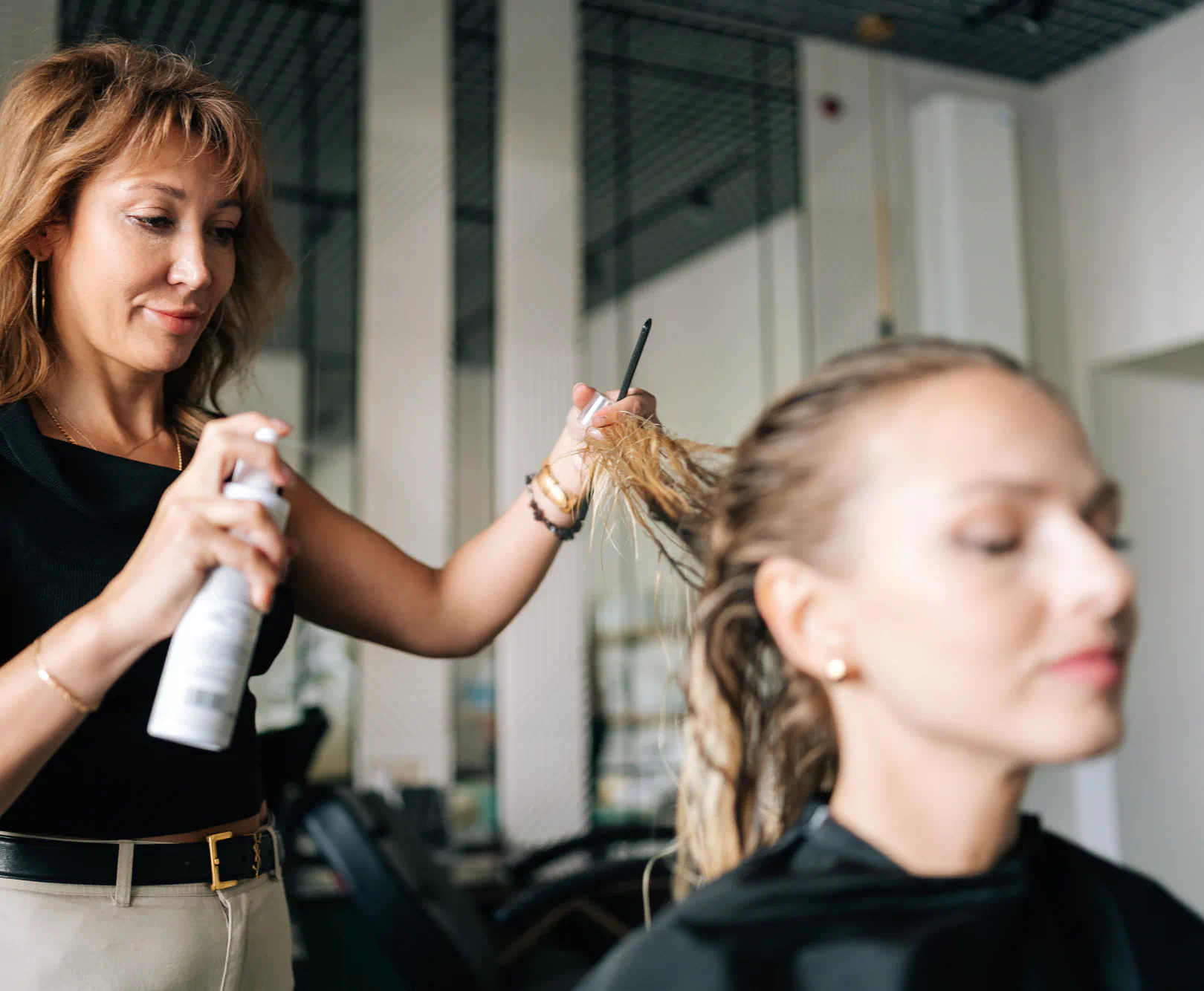 Woman in a salon chair getting her hair done by a stylist