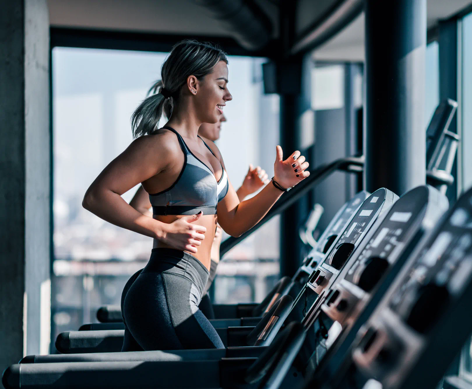 Two woman running on treadmills at a gym