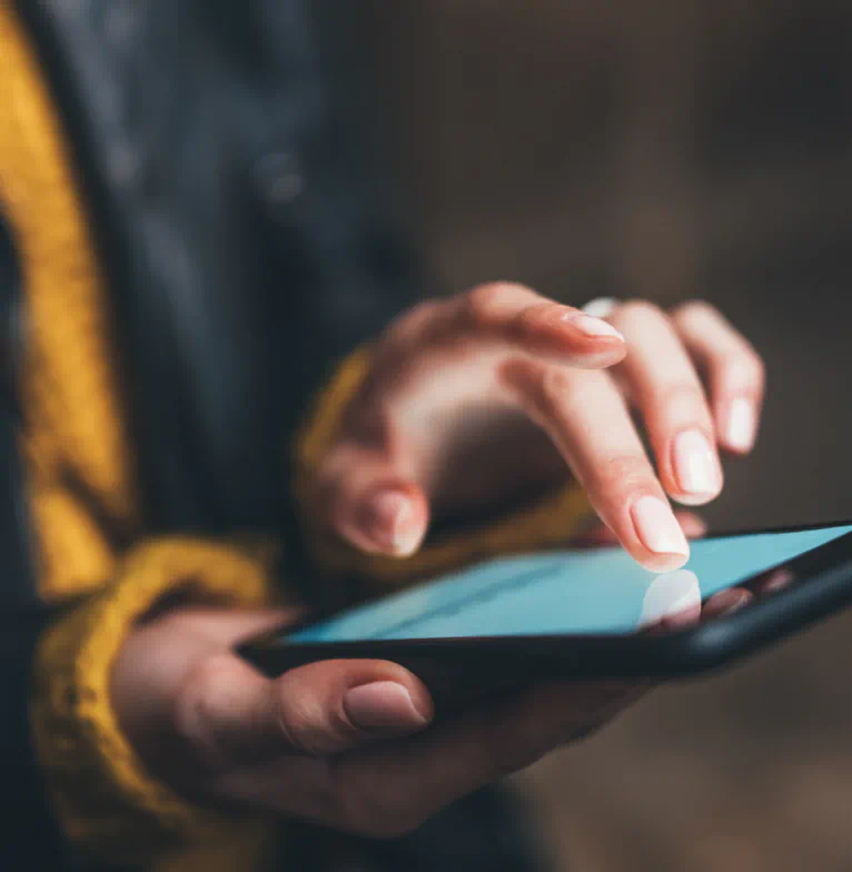Close up of a woman holding a phone and scrolling.