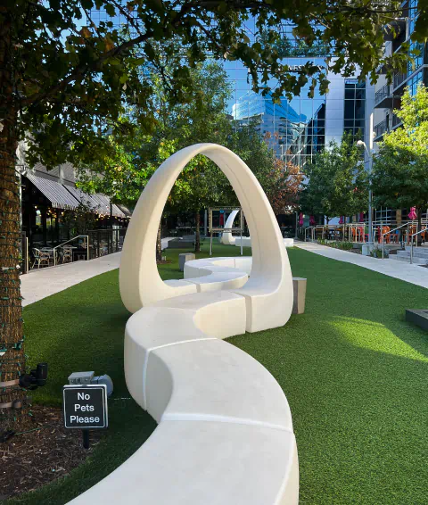 A white sculpture extends across a green lawn.